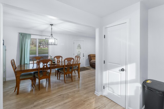 dining space with a notable chandelier and light hardwood / wood-style floors