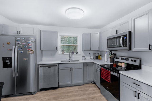 kitchen featuring gray cabinets, sink, light hardwood / wood-style floors, and stainless steel appliances