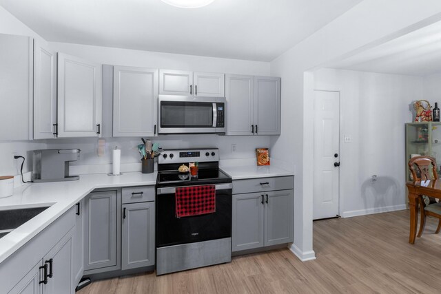 kitchen featuring gray cabinets, stainless steel appliances, and light hardwood / wood-style flooring