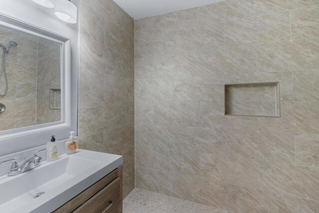 bathroom featuring vanity and tiled shower