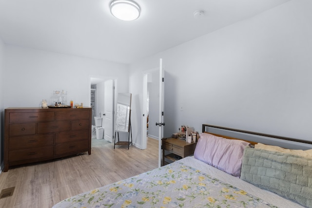 bedroom with light hardwood / wood-style floors and connected bathroom