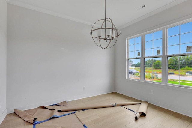 empty room featuring wood-type flooring, crown molding, and an inviting chandelier