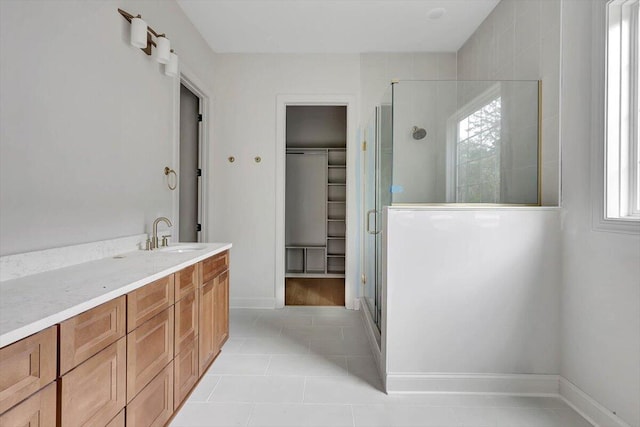 bathroom featuring a healthy amount of sunlight, vanity, tile patterned floors, and a shower with shower door