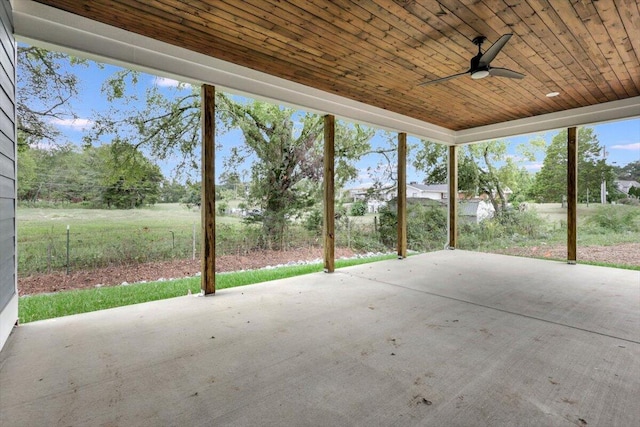 unfurnished sunroom with wood ceiling and ceiling fan