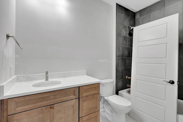 full bathroom with tiled shower / bath, vanity, and toilet