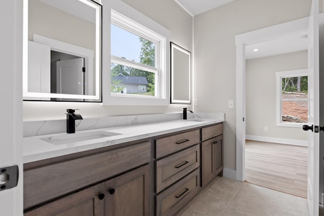 bathroom featuring tile patterned flooring, vanity, and a healthy amount of sunlight