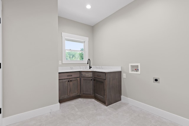 laundry room featuring hookup for an electric dryer, hookup for a washing machine, cabinets, and sink