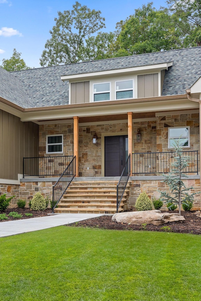 view of exterior entry featuring a porch and a yard