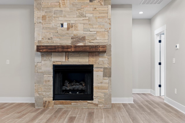 details with a stone fireplace and hardwood / wood-style floors