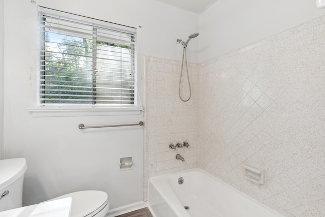 bathroom featuring tiled shower / bath and toilet