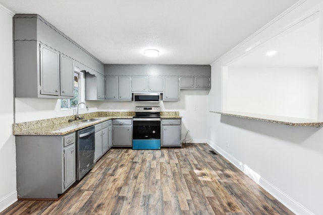 kitchen featuring gray cabinets, crown molding, dark hardwood / wood-style floors, and stainless steel appliances