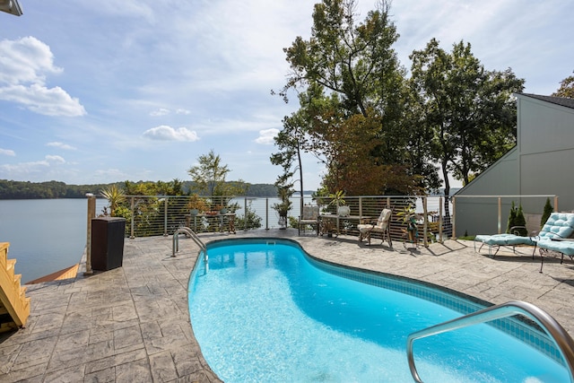 view of swimming pool with a water view and a patio