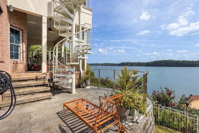 view of patio / terrace featuring ceiling fan, a water view, and a porch