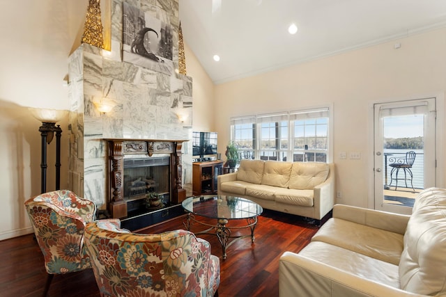 living room with dark hardwood / wood-style floors, a stone fireplace, crown molding, and high vaulted ceiling