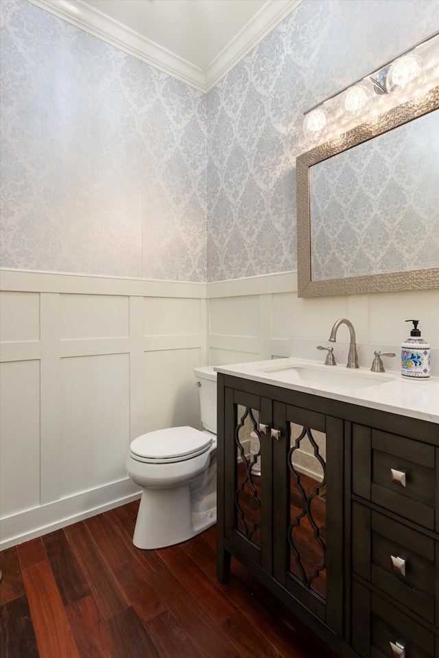 bathroom featuring hardwood / wood-style flooring, vanity, toilet, and crown molding