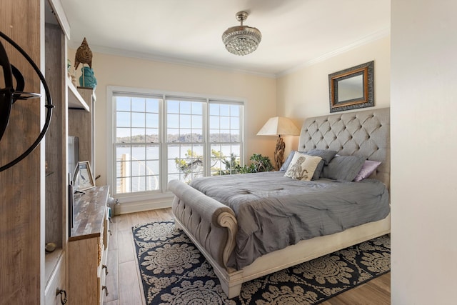 bedroom with light wood-type flooring, a water view, and ornamental molding