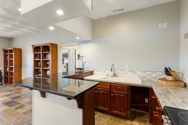 kitchen featuring a kitchen bar, sink, a kitchen island, and range