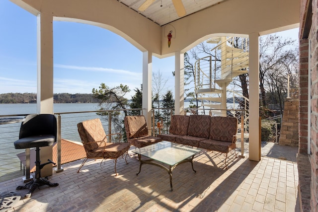 view of patio / terrace featuring an outdoor living space, a balcony, a water view, and ceiling fan