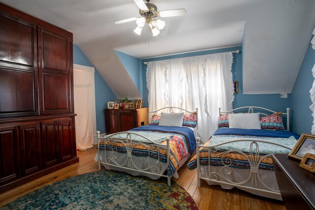 bedroom featuring ceiling fan, vaulted ceiling, and light hardwood / wood-style floors