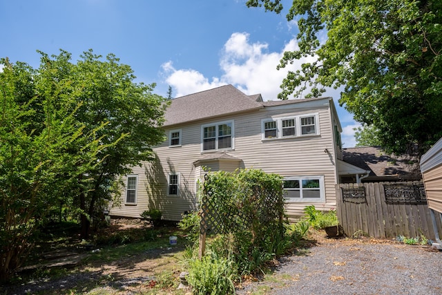 exterior space featuring a shingled roof and fence