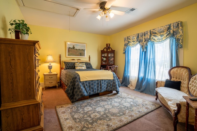 bedroom with carpet flooring, a ceiling fan, visible vents, and attic access