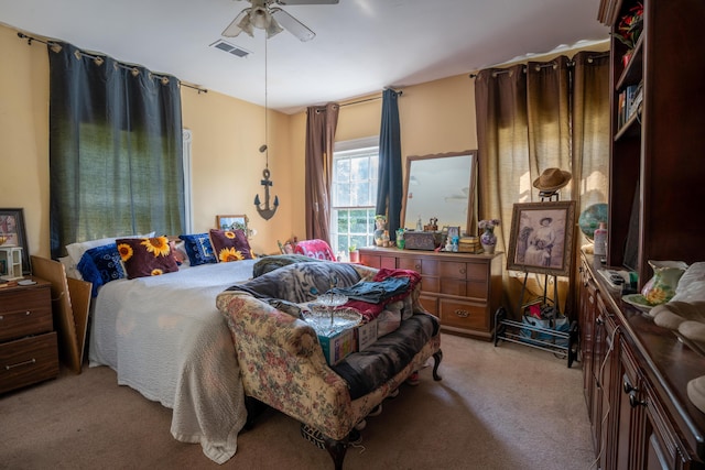 bedroom featuring ceiling fan, visible vents, and light carpet