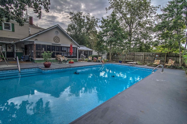 view of pool featuring a sunroom and a patio