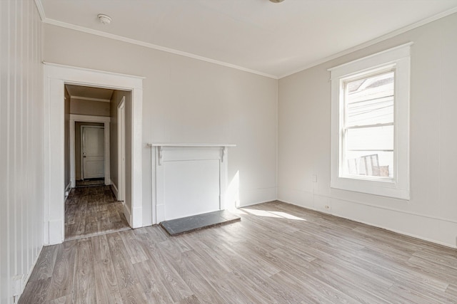 empty room with crown molding and light hardwood / wood-style flooring