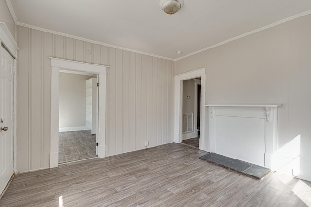 spare room featuring crown molding and light hardwood / wood-style flooring