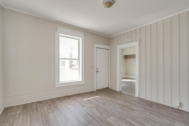 unfurnished room featuring light hardwood / wood-style floors and crown molding