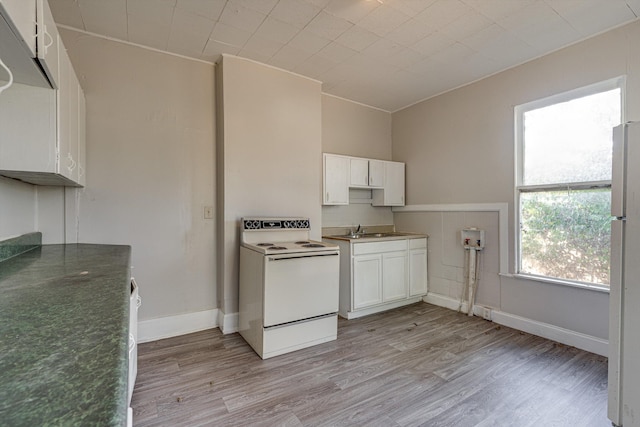 kitchen with white appliances, white cabinets, and light hardwood / wood-style floors