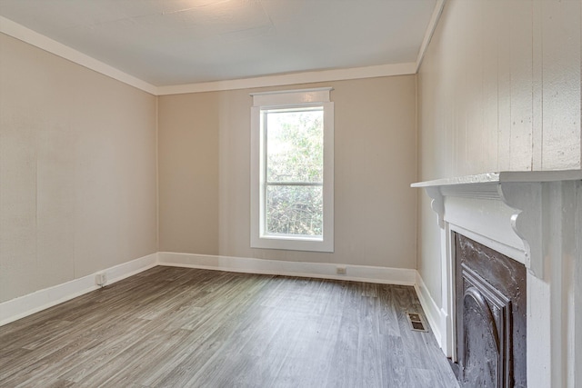 unfurnished living room with crown molding and hardwood / wood-style flooring