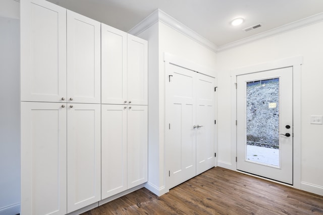 entryway with ornamental molding and dark hardwood / wood-style flooring