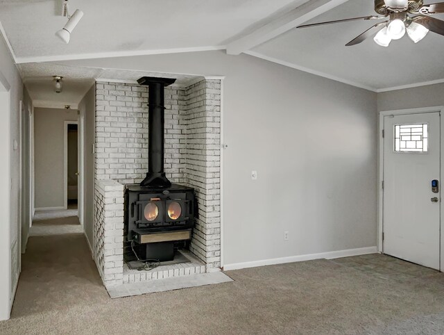 unfurnished living room featuring a wood stove and carpet floors