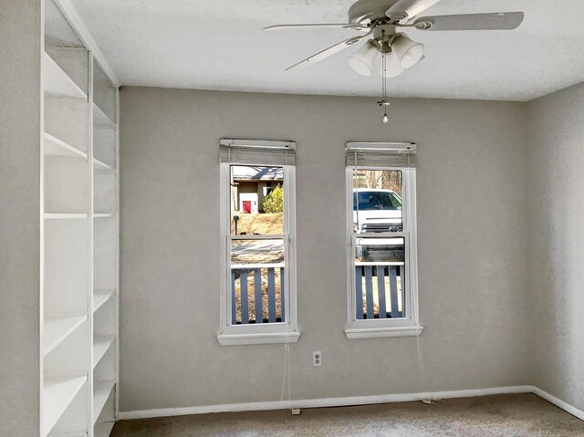 carpeted empty room featuring ceiling fan