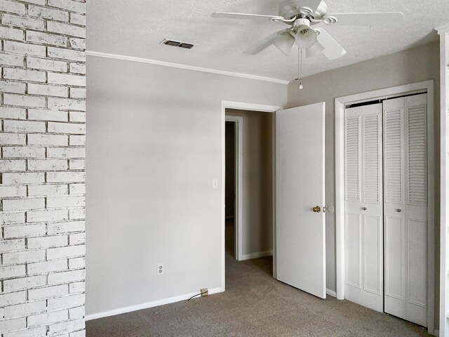 unfurnished bedroom featuring a closet, ceiling fan, ornamental molding, and carpet floors