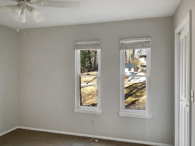 unfurnished room featuring a healthy amount of sunlight, ceiling fan, and carpet