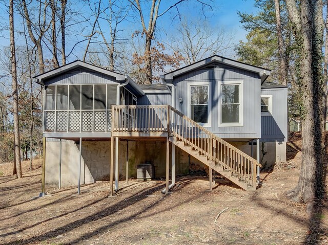 back of house with central AC unit and a sunroom