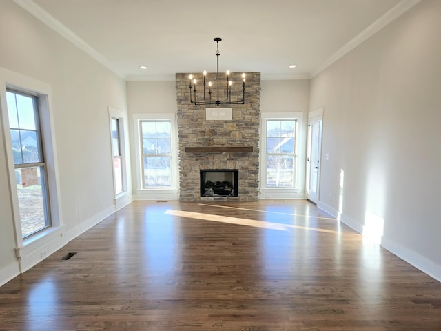 unfurnished living room featuring a wealth of natural light, crown molding, dark hardwood / wood-style flooring, and a notable chandelier