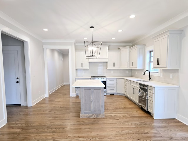 kitchen featuring white cabinets, decorative light fixtures, a center island, and appliances with stainless steel finishes