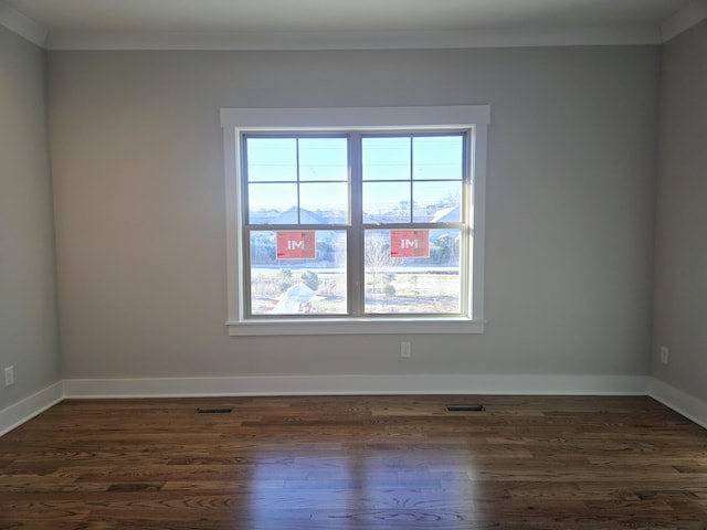 empty room featuring crown molding and dark wood-type flooring