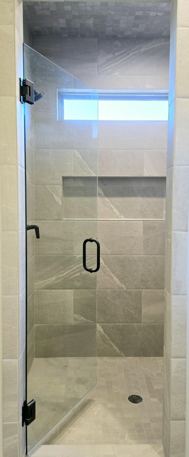 bathroom with a shower with door