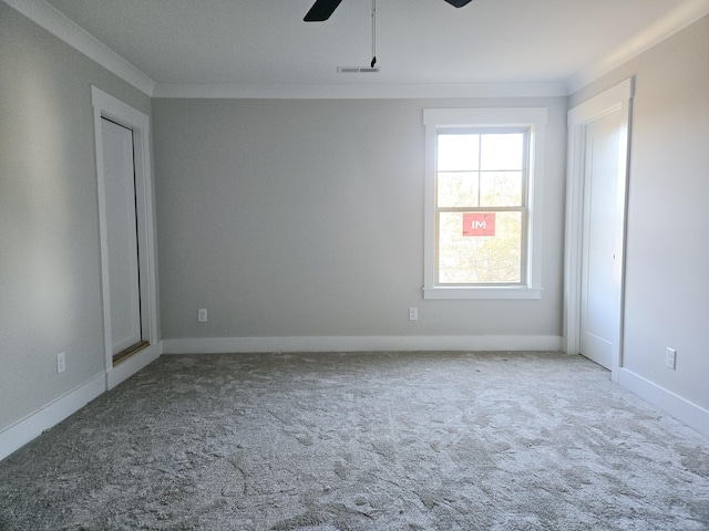 carpeted empty room with ceiling fan and ornamental molding