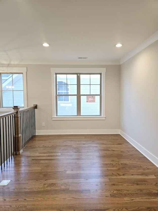 empty room with dark hardwood / wood-style flooring and ornamental molding