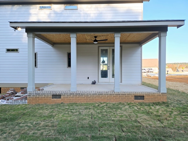 property entrance featuring a lawn and ceiling fan