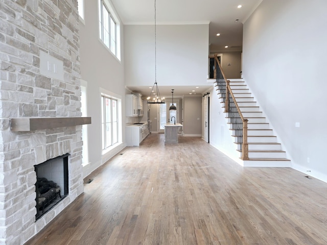 unfurnished living room featuring a fireplace, a high ceiling, and hardwood / wood-style flooring