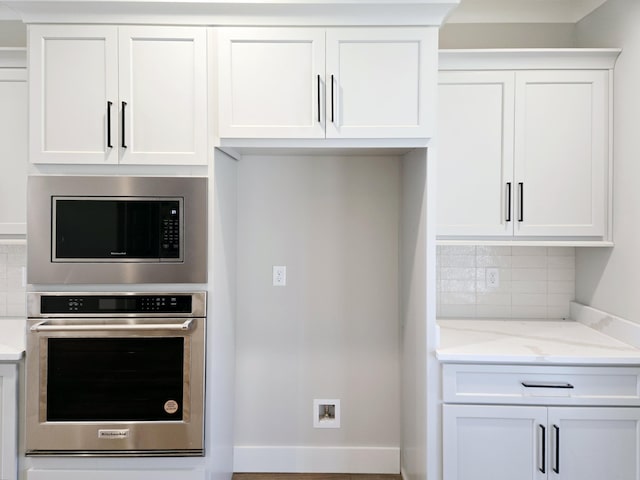 kitchen with white cabinets, oven, decorative backsplash, and built in microwave