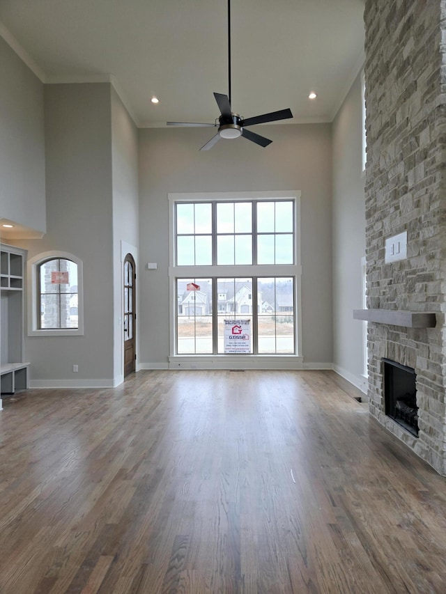 unfurnished living room featuring a high ceiling, hardwood / wood-style flooring, and a healthy amount of sunlight