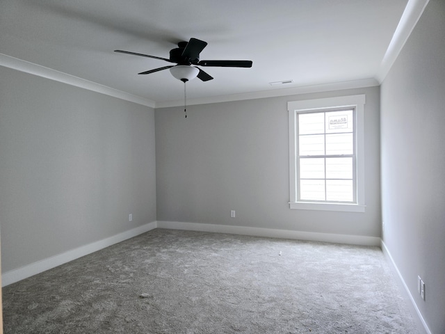 empty room featuring ceiling fan, carpet floors, and ornamental molding