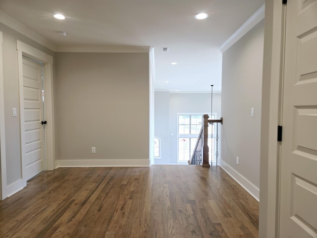 spare room featuring dark hardwood / wood-style floors and crown molding